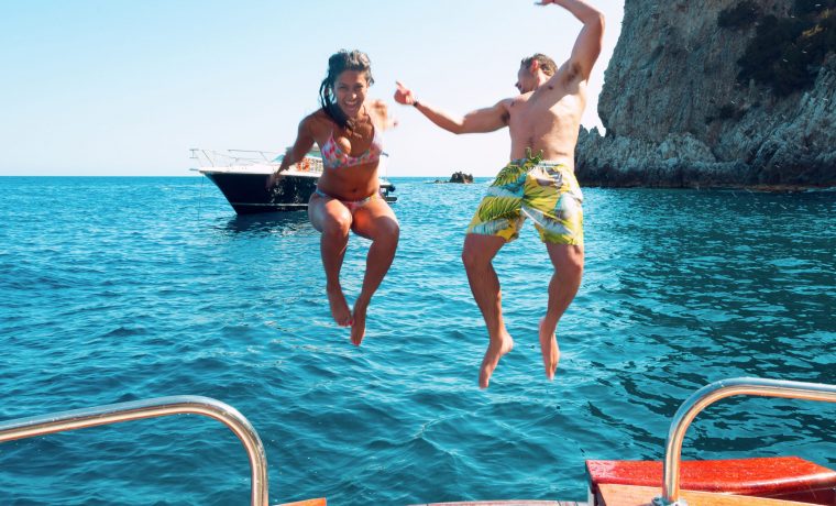 Two guests jump into the waters of Capri on a boat excursion